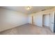 This vacant bedroom features a neutral color palette, plush carpet, and an open doorway leading to an attached bathroom at 264 Towns Cir, Haines City, FL 33844