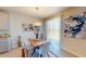 Bright dining area with a modern table, chairs, and artwork, connected to the kitchen and outdoor views at 264 Towns Cir, Haines City, FL 33844