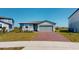 Inviting single-story home featuring a brick driveway and a well-manicured lawn at 264 Towns Cir, Haines City, FL 33844