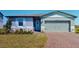 Charming single-story home with light blue shutters, front door, and a brick driveway at 264 Towns Cir, Haines City, FL 33844