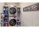 Efficient laundry room with stacked washer and dryer and organized shelving for storage solutions at 264 Towns Cir, Haines City, FL 33844