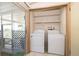 Convenient laundry area with washer, dryer, and shelving for storage solutions at 2650 Einwood Dr, Kissimmee, FL 34758