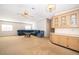 Bright living room featuring a ceiling fan, carpeted floors, and a blue sectional sofa at 2650 Einwood Dr, Kissimmee, FL 34758
