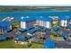 An aerial view of the condo community, showcasing the blue roofs, parking, and mature landscaping at 2700 N Peninsula Ave # 215, New Smyrna Beach, FL 32169