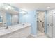 The primary bathroom features a double sink vanity, a large mirror, and a glass enclosed shower at 2700 N Peninsula Ave # 215, New Smyrna Beach, FL 32169