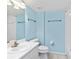 A standard bathroom with a white sink, toilet, and shower with light-blue colored walls at 2700 N Peninsula Ave # 215, New Smyrna Beach, FL 32169