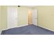 A guest bedroom with carpeting and a door to the outside hallway at 2700 N Peninsula Ave # 215, New Smyrna Beach, FL 32169