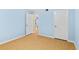A bedroom with a hardwood floor, light blue walls, and two entryways at 2700 N Peninsula Ave # 215, New Smyrna Beach, FL 32169