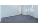 Cozy bedroom features blue carpeting, light blue walls and a bay window with plantation shutters at 2700 N Peninsula Ave # 215, New Smyrna Beach, FL 32169