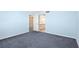 A calm bedroom with blue carpeting, light blue walls, and doors to the closet and bathroom at 2700 N Peninsula Ave # 215, New Smyrna Beach, FL 32169