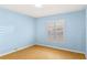 A light-blue painted bedroom with a hardwood floor and a window with white shutters at 2700 N Peninsula Ave # 215, New Smyrna Beach, FL 32169