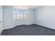 A comfy bedroom features blue carpeting, light blue walls and a bay window with plantation shutters at 2700 N Peninsula Ave # 215, New Smyrna Beach, FL 32169