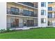 Exterior condo view featuring a screened balcony, lush greenery, and well-maintained landscaping at 2700 N Peninsula Ave # 215, New Smyrna Beach, FL 32169
