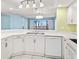 Open kitchen boasts stainless steel sink, white cabinets, and pool views at 2700 N Peninsula Ave # 215, New Smyrna Beach, FL 32169