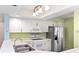 Open kitchen with white cabinets, stainless steel appliances, and modern countertops at 2700 N Peninsula Ave # 215, New Smyrna Beach, FL 32169