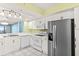 Modern kitchen with stainless steel appliances, white cabinets, and breakfast bar at 2700 N Peninsula Ave # 215, New Smyrna Beach, FL 32169