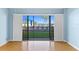 Living room view showcasing the pool and palm trees through sliding glass doors at 2700 N Peninsula Ave # 215, New Smyrna Beach, FL 32169
