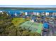 This image showcases the community tennis courts surrounded by lush greenery and blue roofed carports at 2700 N Peninsula Ave # 215, New Smyrna Beach, FL 32169