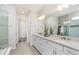 Bright bathroom featuring double sinks with granite countertops and a glass shower enclosure at 2749 Serenity Meadow Dr, Kissimmee, FL 34744