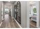 Hallway with luxury vinyl plank flooring and unique arched mirrors leading to the living spaces at 2749 Serenity Meadow Dr, Kissimmee, FL 34744