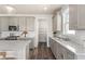 View of the kitchen showcasing stainless steel appliances, white backsplash and grey cabinetry at 2749 Serenity Meadow Dr, Kissimmee, FL 34744