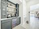 Modern bar with custom cabinets and shelving. Wine fridge and beverage center for entertaining at 3182 Sailing Pier Ave, Winter Garden, FL 34787