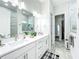 Modern bathroom features double vanity, large mirror, and marble tiled shower at 3182 Sailing Pier Ave, Winter Garden, FL 34787