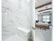Elegant glass shower with marble tiled surround and bench seat that opens to main bedroom at 3182 Sailing Pier Ave, Winter Garden, FL 34787