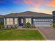 Beautiful single-story home featuring a two-car garage, manicured lawn, and a charming brick walkway at 3182 Sailing Pier Ave, Winter Garden, FL 34787