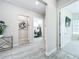 Hallway featuring wood-look tile flooring, neutral walls, and views into a home office space at 3182 Sailing Pier Ave, Winter Garden, FL 34787