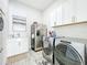 Well-equipped laundry room with modern washer and dryer, stainless steel refrigerator, and ample storage at 3182 Sailing Pier Ave, Winter Garden, FL 34787