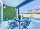 Relaxing outdoor patio with an artificial grass wall, a table and four chairs near the sparkling swimming pool at 3182 Sailing Pier Ave, Winter Garden, FL 34787