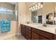 Bright bathroom featuring a double sink vanity, large mirror, and a tiled shower with glass door at 3375 Bellino Blvd., New Smyrna Beach, FL 32168