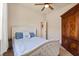 Well-lit bedroom featuring a comfortable bed with stylish linens, a ceiling fan, and a wooden wardrobe at 3375 Bellino Blvd., New Smyrna Beach, FL 32168