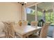 Cozy dining area with outdoor views, featuring a light wood table, matching chairs, and access to an outdoor kitchen at 3375 Bellino Blvd., New Smyrna Beach, FL 32168