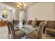 Formal dining room featuring a glass table with patterned chairs, chandelier lighting, and neutral decor at 3375 Bellino Blvd., New Smyrna Beach, FL 32168