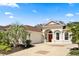 Charming home featuring a red door, meticulously landscaped yard with palm trees, and an attached two-car garage at 3375 Bellino Blvd., New Smyrna Beach, FL 32168