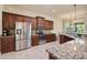 This kitchen features stainless steel appliances, granite countertops, tile floors, and dark wood cabinetry at 3375 Bellino Blvd., New Smyrna Beach, FL 32168
