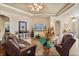Inviting living room with a ceiling fan, tile floors, comfortable leather furniture, and a decorative entertainment center at 3375 Bellino Blvd., New Smyrna Beach, FL 32168