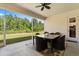 Screened-in patio with a tile-top table, woven chairs, and a view of the backyard at 3375 Bellino Blvd., New Smyrna Beach, FL 32168
