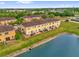 Aerial view of townhomes with lakeside views and manicured lawns at 3462 Allegra Cir, St Cloud, FL 34772