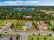 Expansive aerial view showing the property's location, manicured lawn, pool, and proximity to a lake at 3664 Farm Bell Pl, Lake Mary, FL 32746