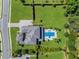 Aerial view of property with a sparkling pool, landscaped backyard, and tree-lined street at 3664 Farm Bell Pl, Lake Mary, FL 32746
