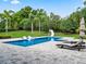 Spacious backyard featuring a large in-ground swimming pool, pool slide, tanning chairs, and lush landscaping at 3664 Farm Bell Pl, Lake Mary, FL 32746