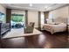 Spacious main bedroom with dark wood floors, recessed lights, and a door leading to the lanai and pool area at 3664 Farm Bell Pl, Lake Mary, FL 32746