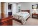 Comfortable bedroom featuring a wooden bed frame with floral comforter and a side table with decorative lamp at 3664 Farm Bell Pl, Lake Mary, FL 32746