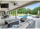 Outdoor seating and kitchen area underneath a large covered patio overlooking the swimming pool and lush landscaping at 3664 Farm Bell Pl, Lake Mary, FL 32746