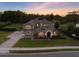 An impressive home exterior with a well-manicured lawn and a stately entrance at dusk at 3664 Farm Bell Pl, Lake Mary, FL 32746