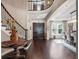 An elegant foyer boasts hardwood floors, a curved staircase, and a view into the dining area at 3664 Farm Bell Pl, Lake Mary, FL 32746