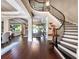 Open floor plan with curved staircase, hardwood floors and a view into the formal living room at 3664 Farm Bell Pl, Lake Mary, FL 32746